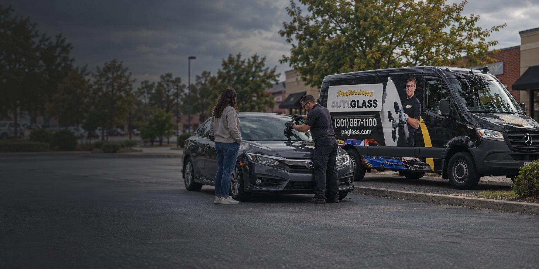 Professional Auto Glass technician replacing a windshield next to the company van
